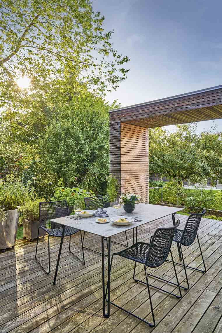 Weishäupl Slope Tisch: Moderner Esstisch für den Außenbereich mit Stühlen auf einer Holzterrasse.
