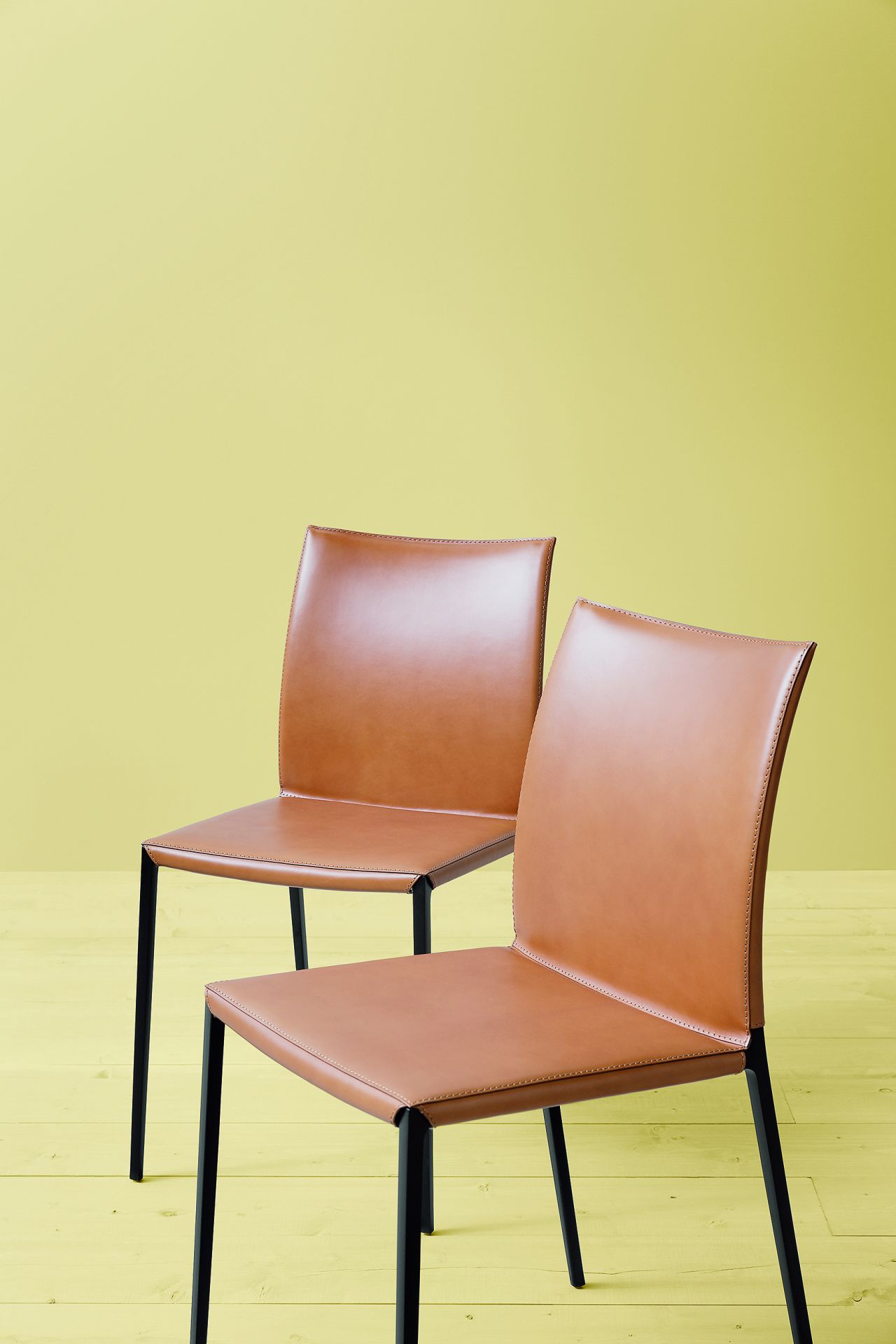 Zwei Lia Stühle von Zanotta ohne Armlehnen, braunes Leder, schwarzes Gestell. Designermöbel für Esszimmer.