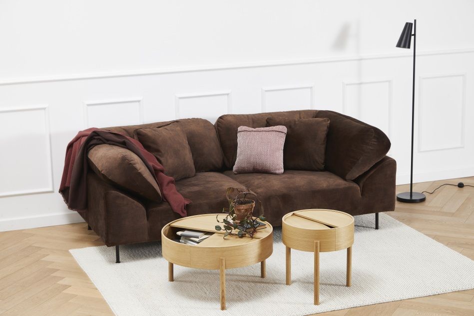 Arc Side Table Beistelltisch Eiche geölt von Woud, runder Holztisch mit Stauraum vor braunem Sofa.
