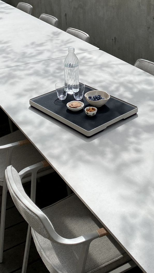Vipp Outdoor Open-Air Tray Tisch mit Wasser, Gläsern, Blaubeeren und Nüssen auf einer Terrasse.