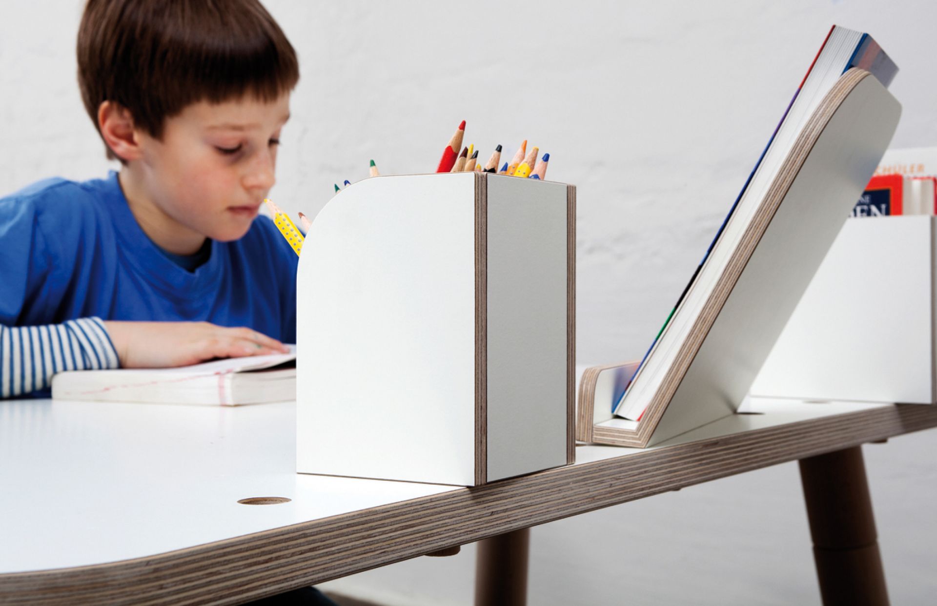 Growing Table Schreibtisch Set: Kind malt am Tisch mit Stiftehalter und Buchstütze in Weiß.