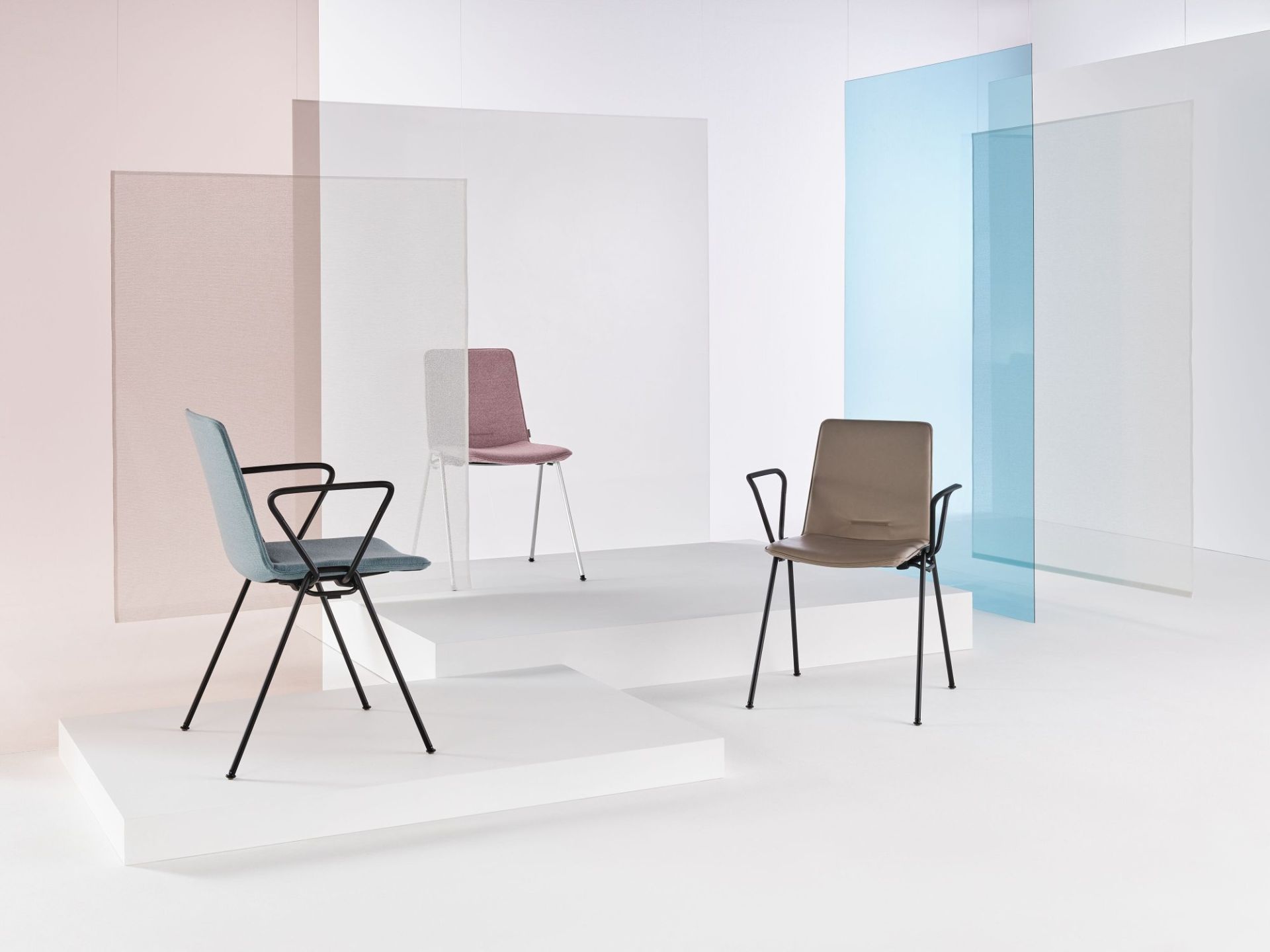 Drei Walter Knoll Yunity Chair Stühle in verschiedenen Farben auf weißen Podesten vor farbigen Glasscheiben.