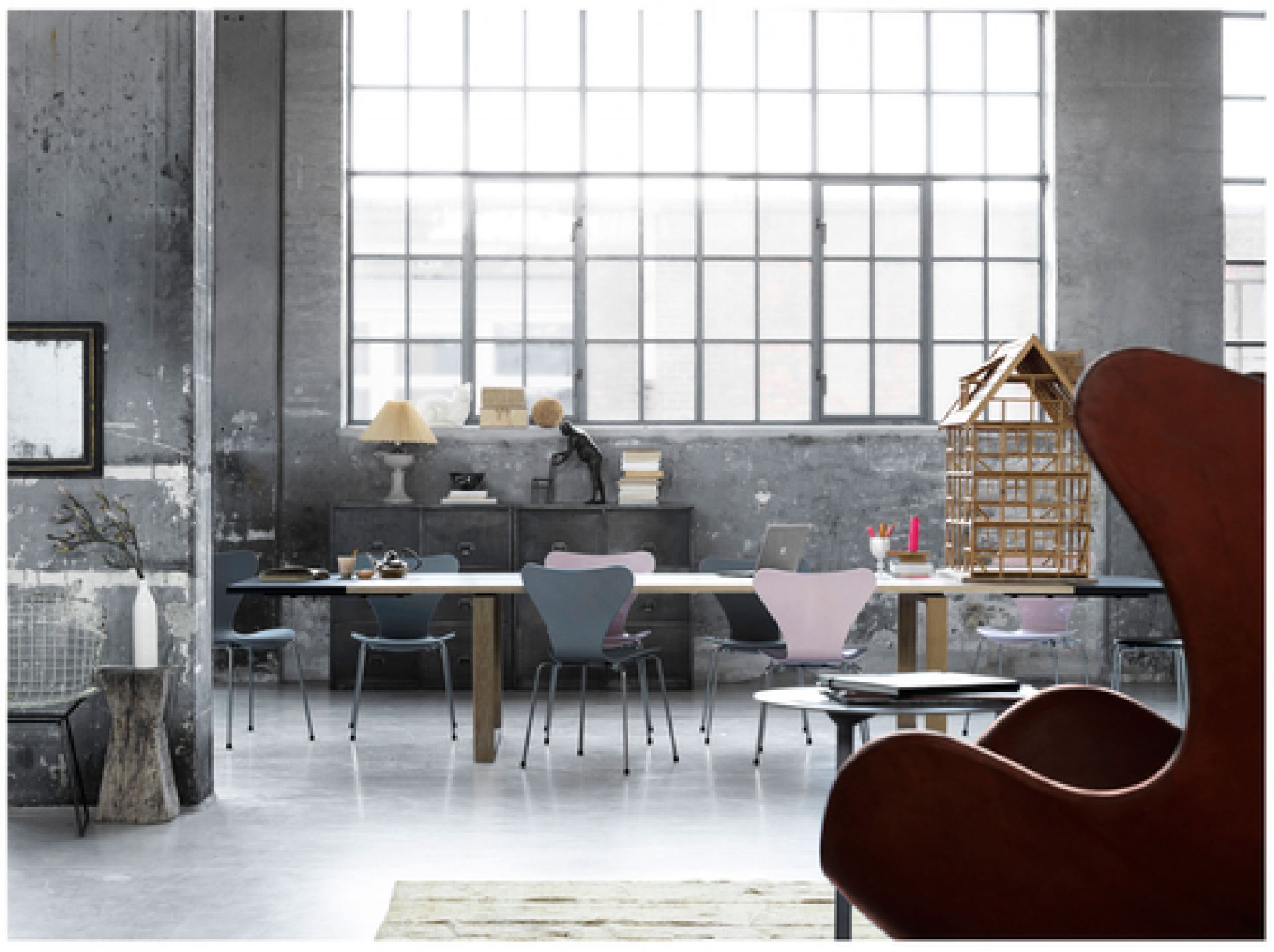 Heller Raum mit Essay Tisch von Fritz Hansen, umgeben von Stühlen und Dekoration.