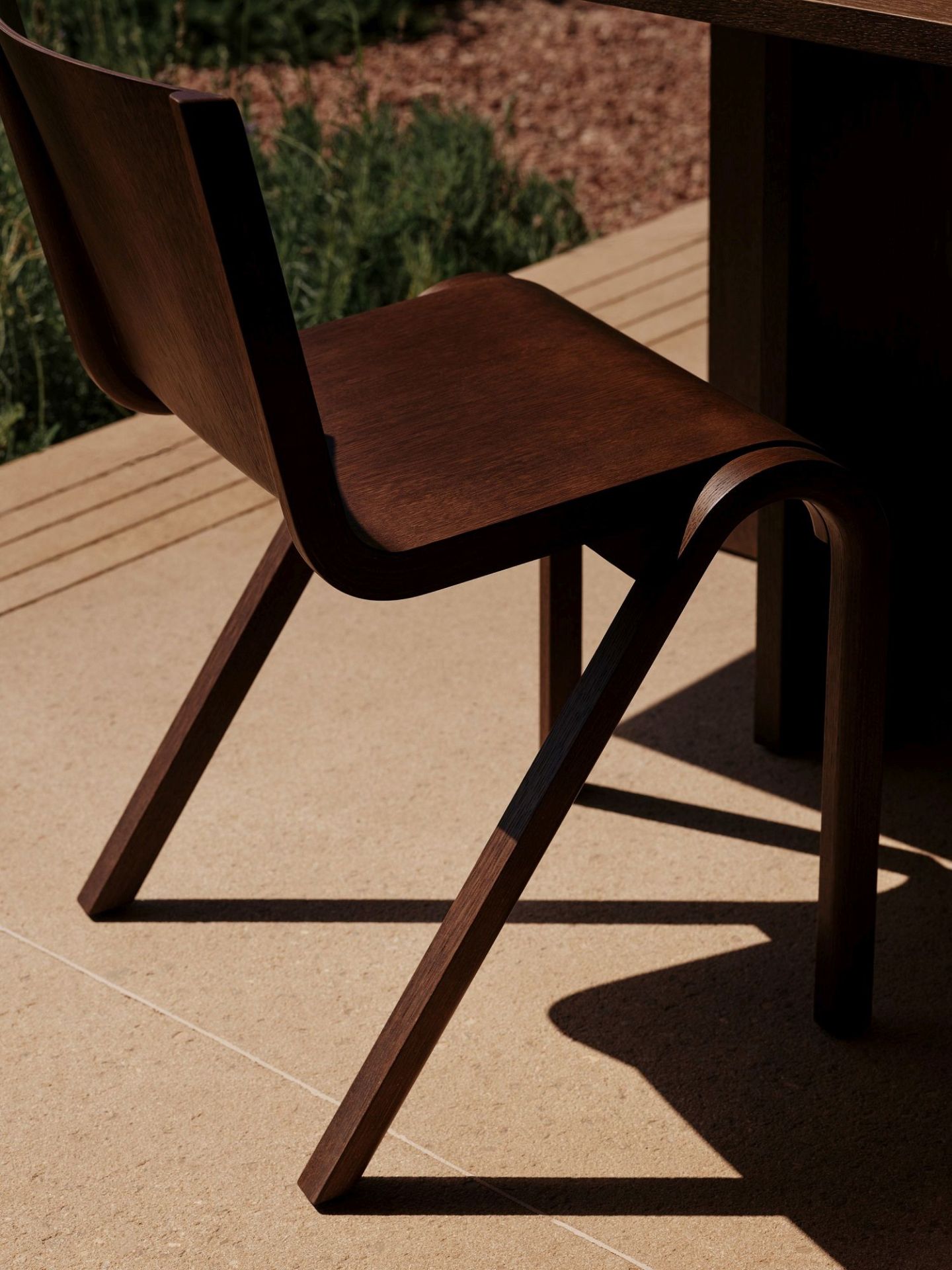 Nahaufnahme des Audo Copenhagen Ready Dining Chair Holzstuhl in dunklem Holz, seitliche Ansicht.