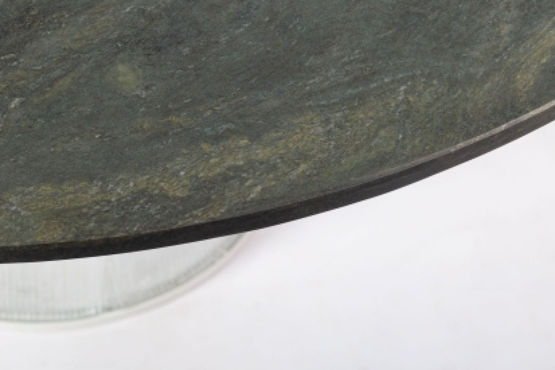 Detailaufnahme: Runde Tischplatte des Bent Dining Table von Pulpo mit grüner Marmorierung.