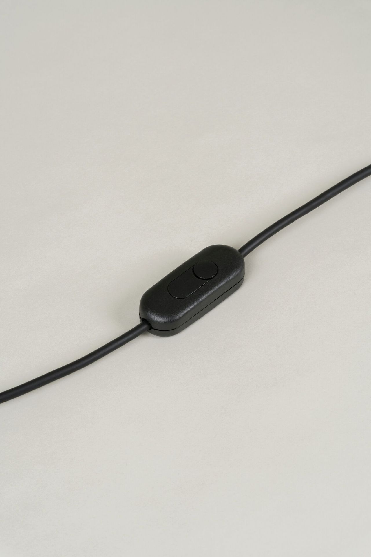 Detailaufnahme des schwarzen Schalters am Kabel der Tripode Tischleuchte von Santa & Cole.
