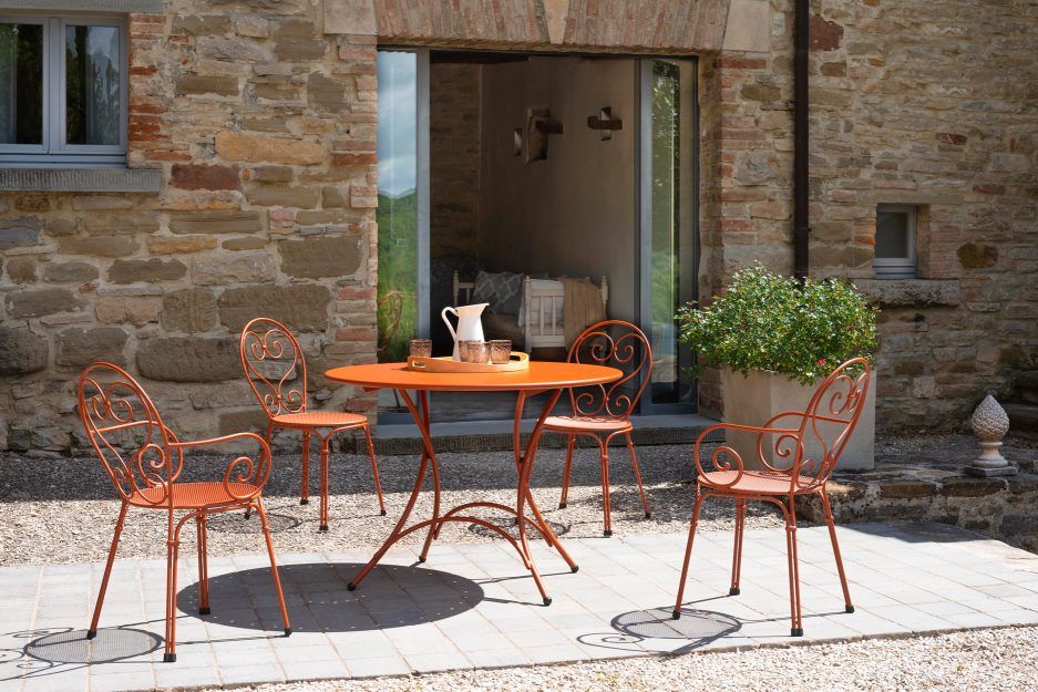 Orangefarbener Pigalle Stuhl von Emu für den Außenbereich, Teil einer Gartensitzgruppe mit Tisch.