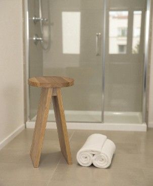 Hocker groß EK02 e15 aus geöltem Holz im Badezimmer mit Handtüchern vor einer Dusche.