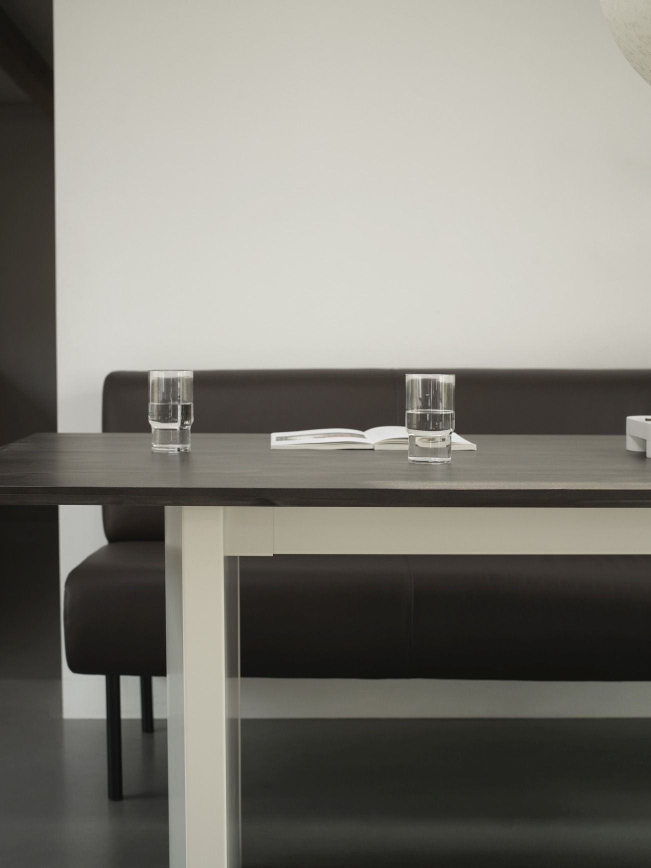 Normann Copenhagen Panel Tisch, Esstisch 200x90 cm mit Gläsern und Buch auf dunkler Tischplatte.