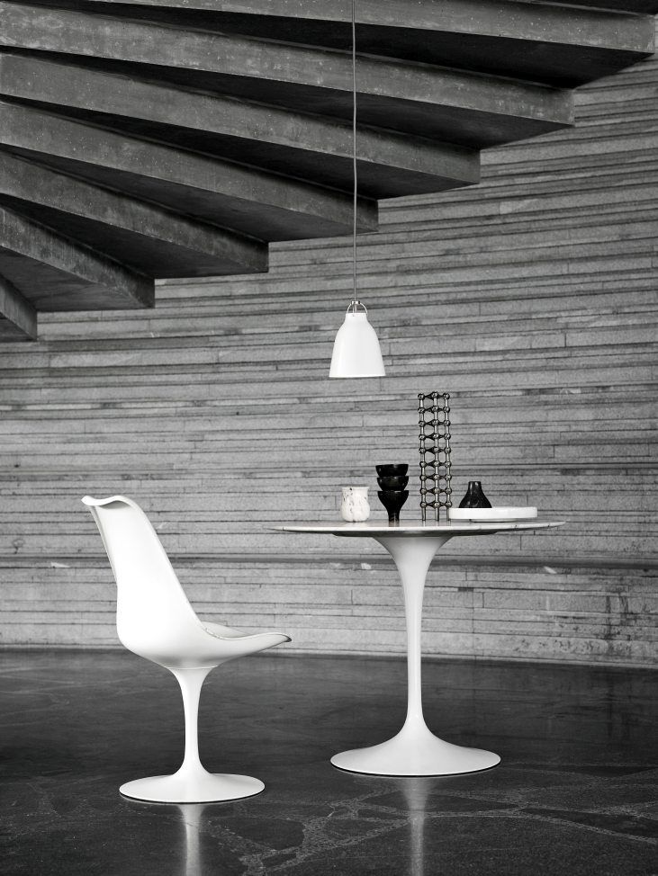Weiße Caravaggio Pendelleuchte von Fritz Hansen über einem Esstisch mit Stuhl in modernem Interieur.