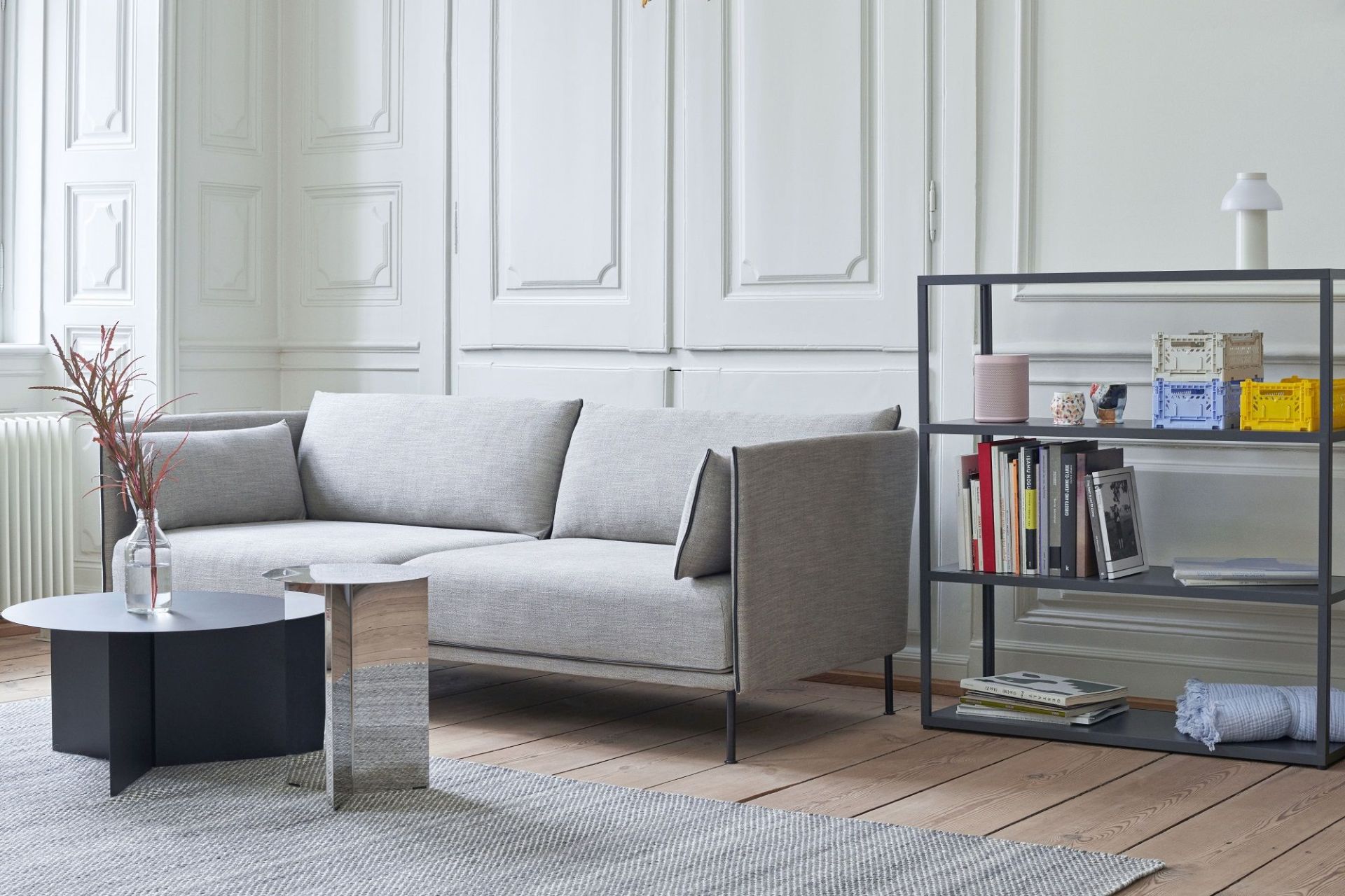 Hay Slit Table Round High Beistelltisch in Silber und Schwarz neben grauem Sofa im Wohnzimmer.