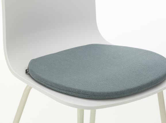 Nahaufnahme eines Soft Seats Sitzkissens "Pebble Grey" von Vitra auf einem weißen Stuhl.