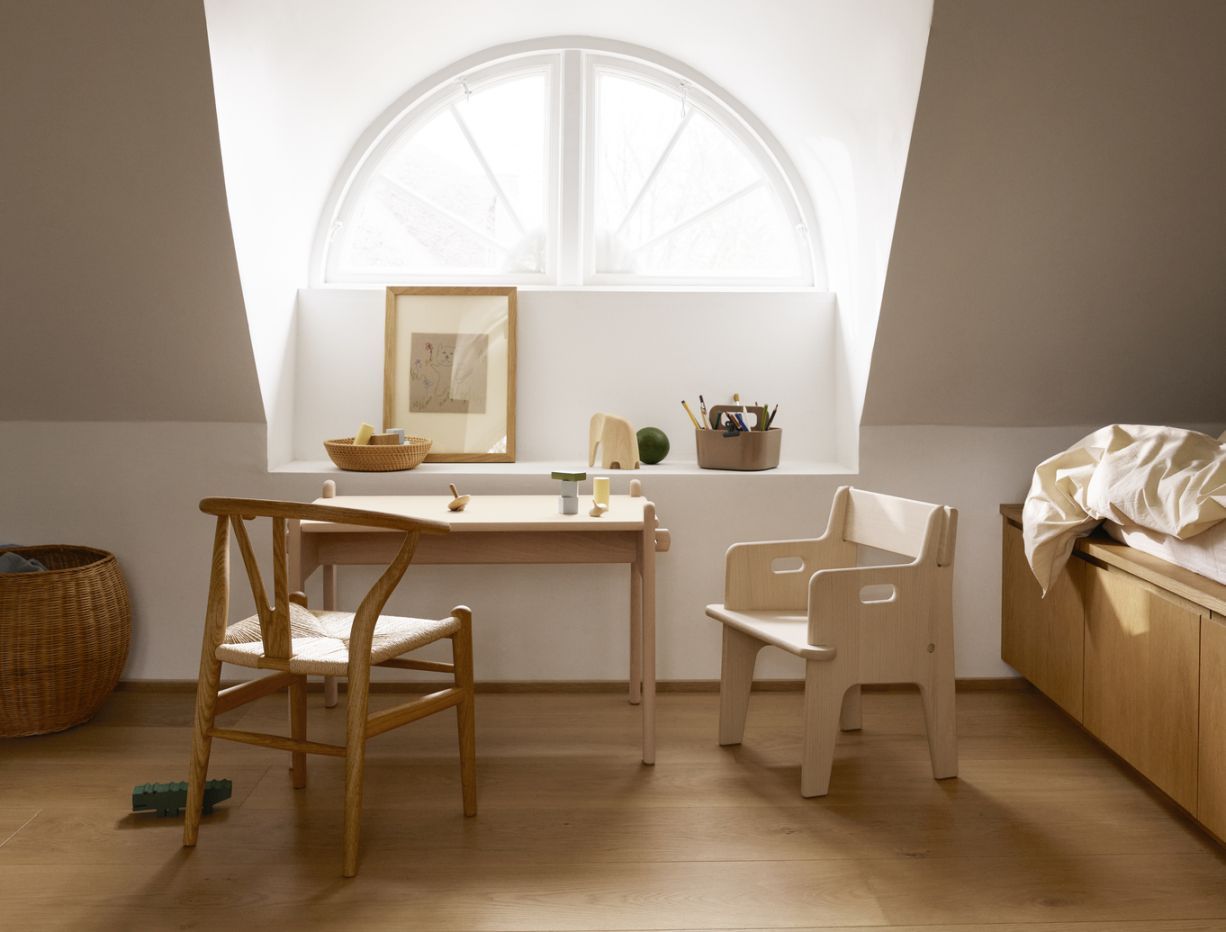 CH24 Wishbone Kinderstuhl von Carl Hansen, helles Holz, geflochtener Sitz, im Kinderzimmer mit Tisch.