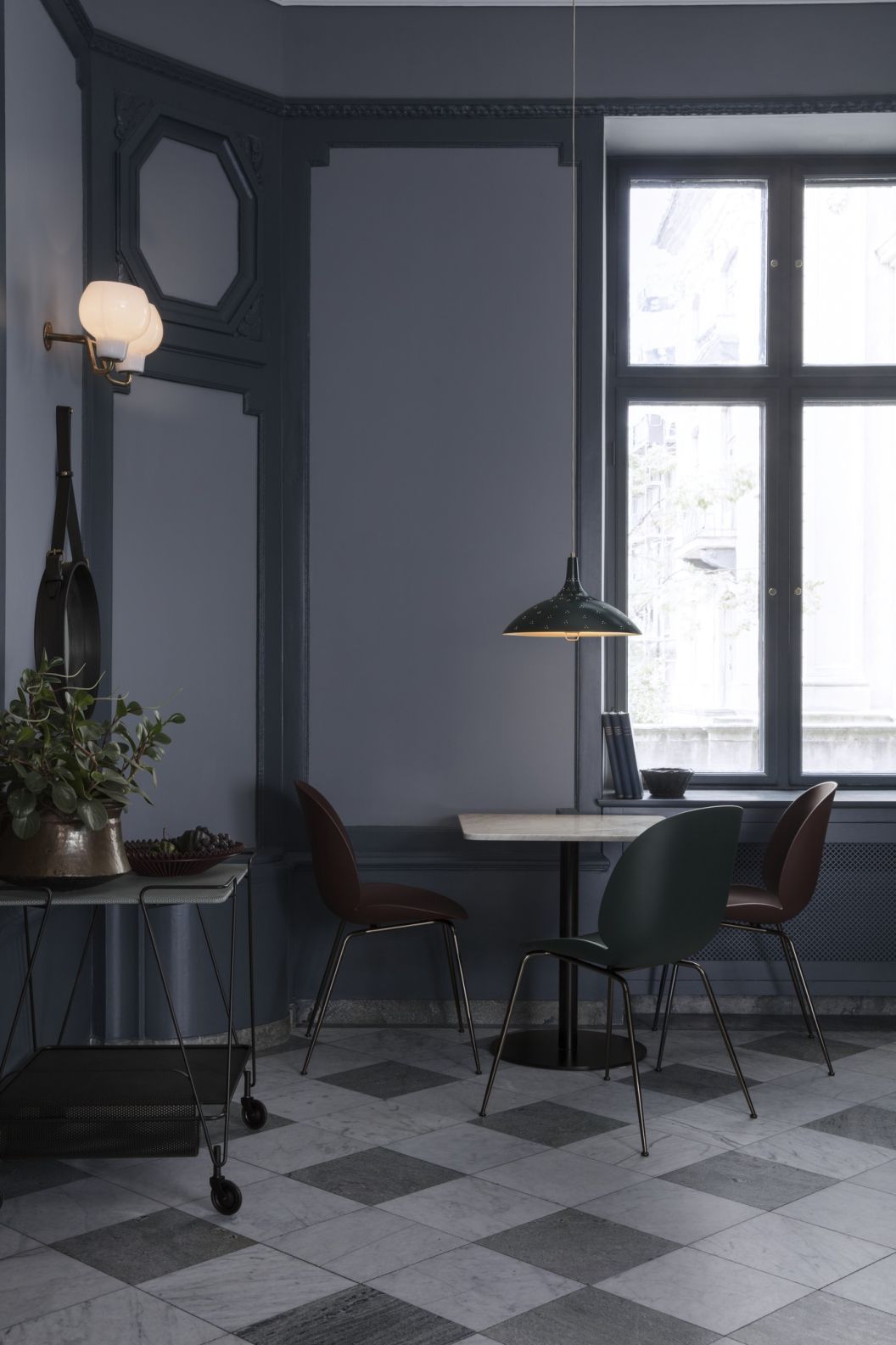 Esszimmer mit Gubi Wandleuchte, Pendelleuchte und Stühlen, stilvolles Interieur mit Marmorboden.