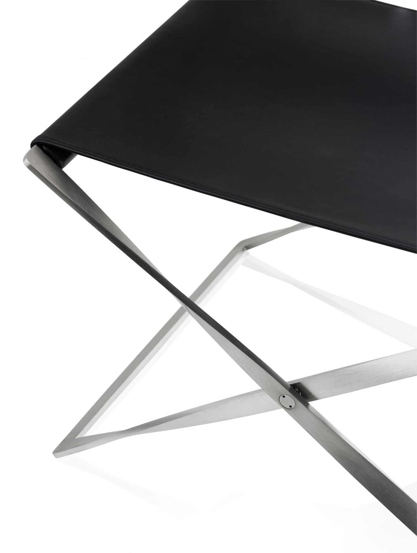 Detailaufnahme des PK91 Falthockers von Fritz Hansen mit schwarzem Leder und Stahlgestell.