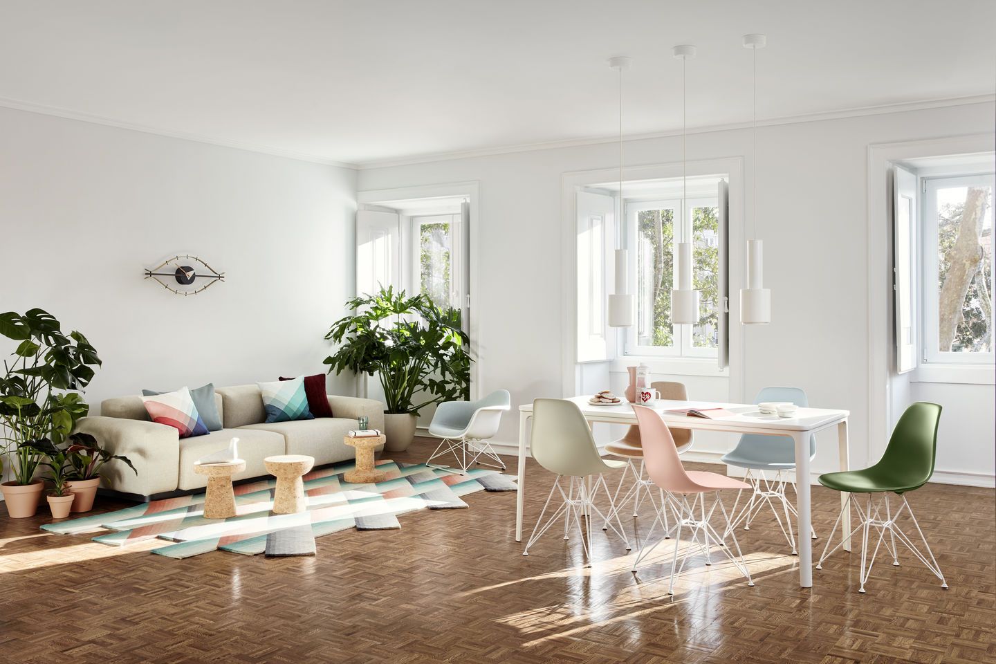 Esszimmer mit Esstisch und mehreren bunten Eames Fiberglass Stühlen DSR mit Sitzpolster von Vitra.