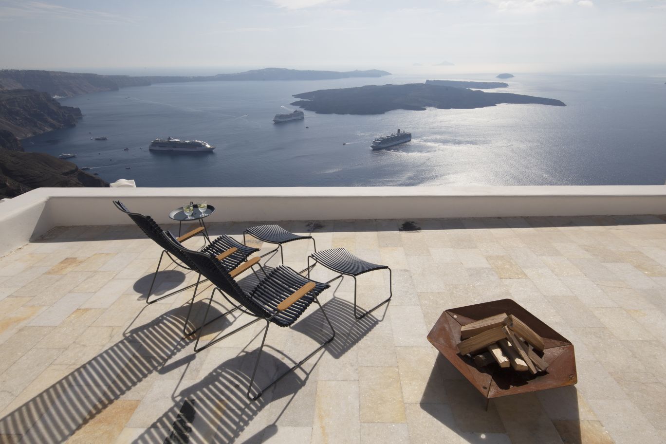 Dunkelgrauer Click Lounge Chair Sessel von Houe auf einer Terrasse mit Meerblick, ideal für entspannte Stunden im Freien.