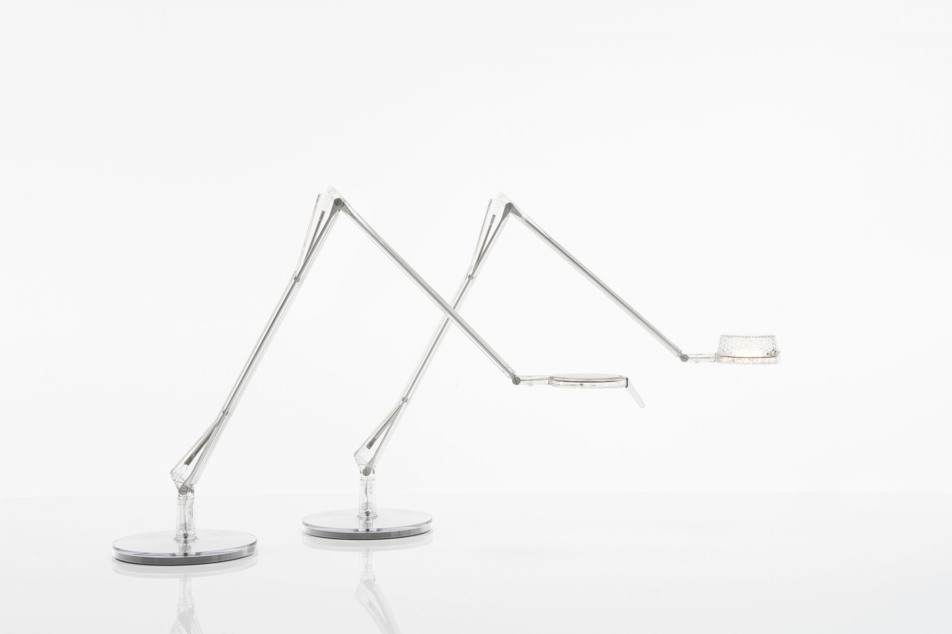 Zwei moderne Aledin Tischleuchten von Kartell mit filigranem Design und LED-Beleuchtung.