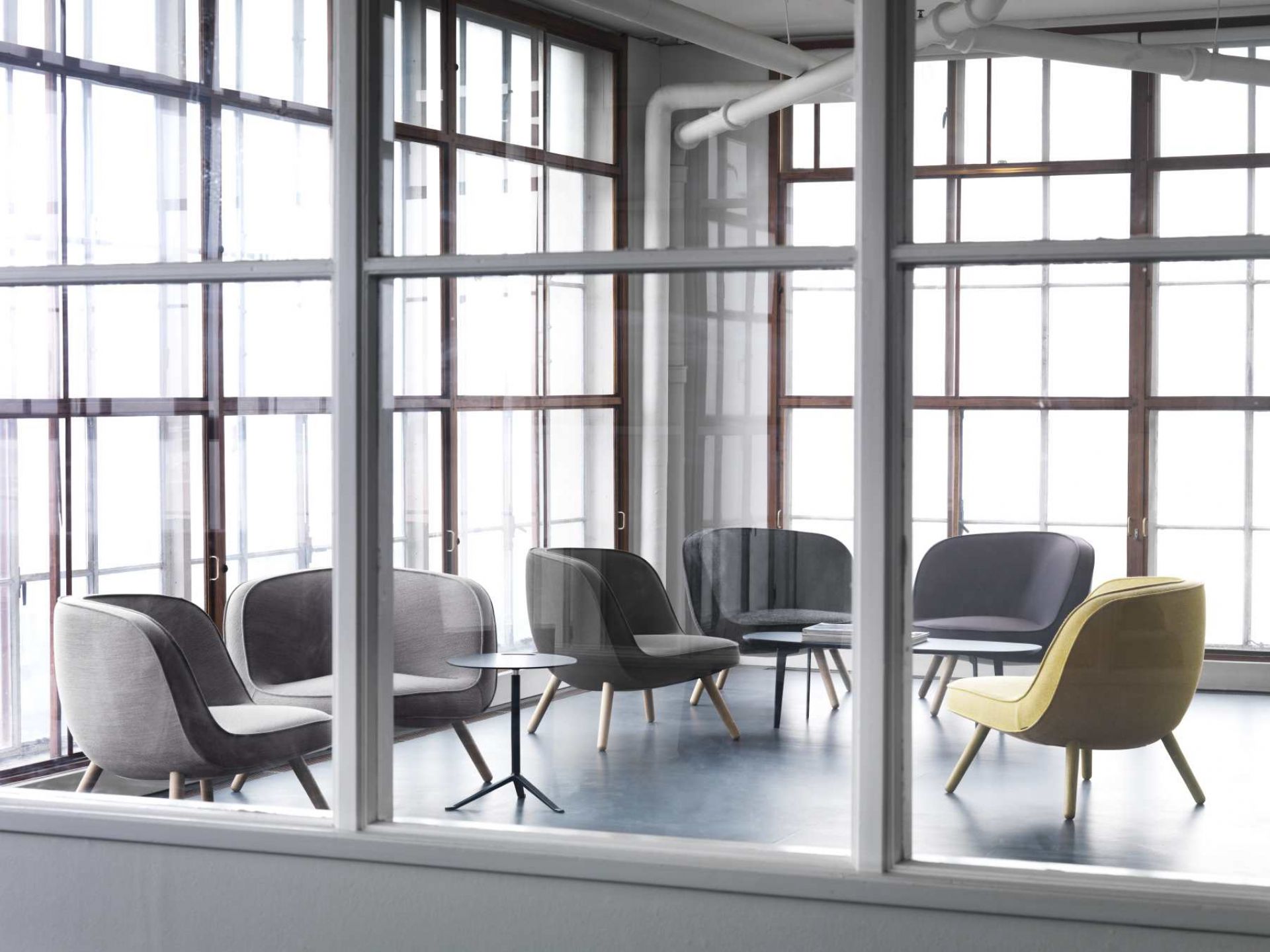 Via57 Sessel von Fritz Hansen in Grau- und Gelbtönen, arrangiert in einem hellen Raum.