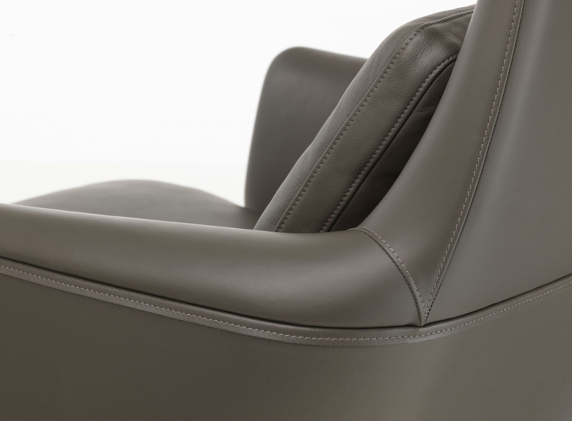 Detailaufnahme vom Vitra Grand Relax Sessel in grauem Leder mit feinen Ziernähten und Armlehne.