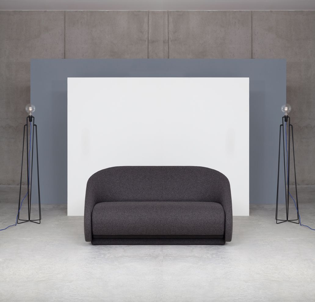 Graues Up-lift Schlafsofa von Prostoria vor weißem Hintergrund, flankiert von zwei Stehlampen.