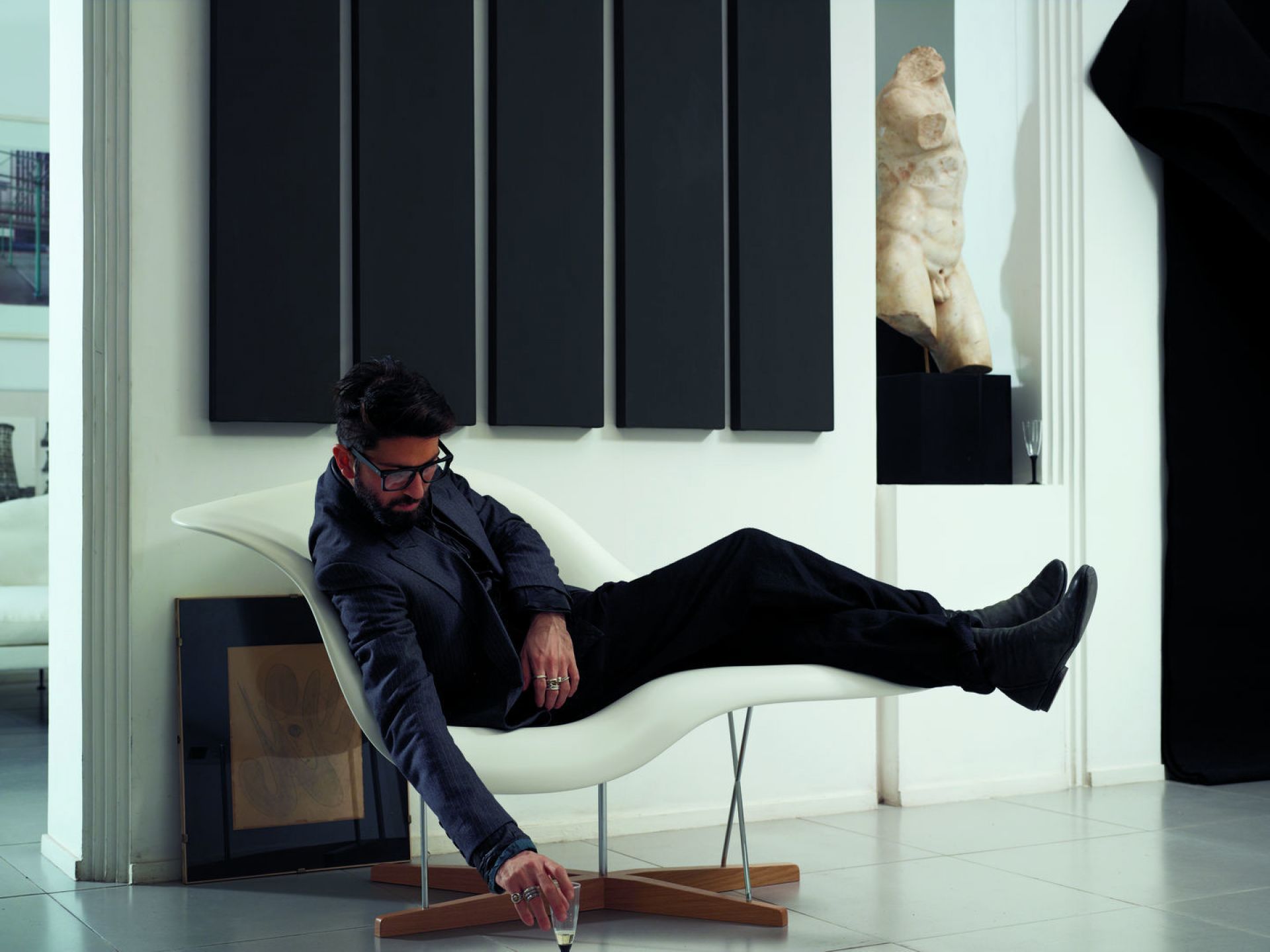 Mann entspannt auf einer weißen La Chaise Liege von Vitra in modernem Interieur.