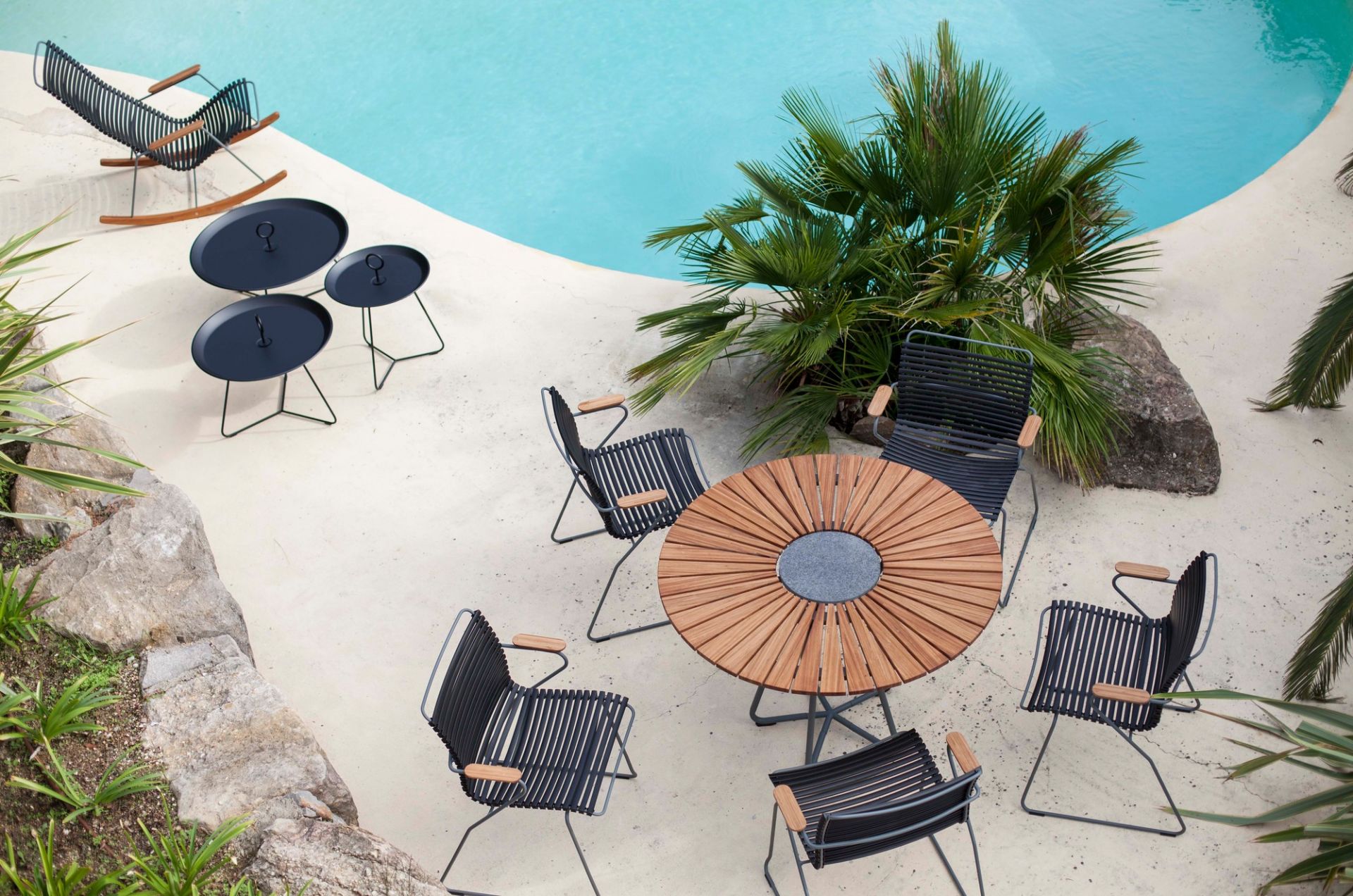 Luftaufnahme: Houe Circle Outdoor Tisch 150 cm aus Teakholz mit Gartenstühlen und Beistelltischen am Pool.