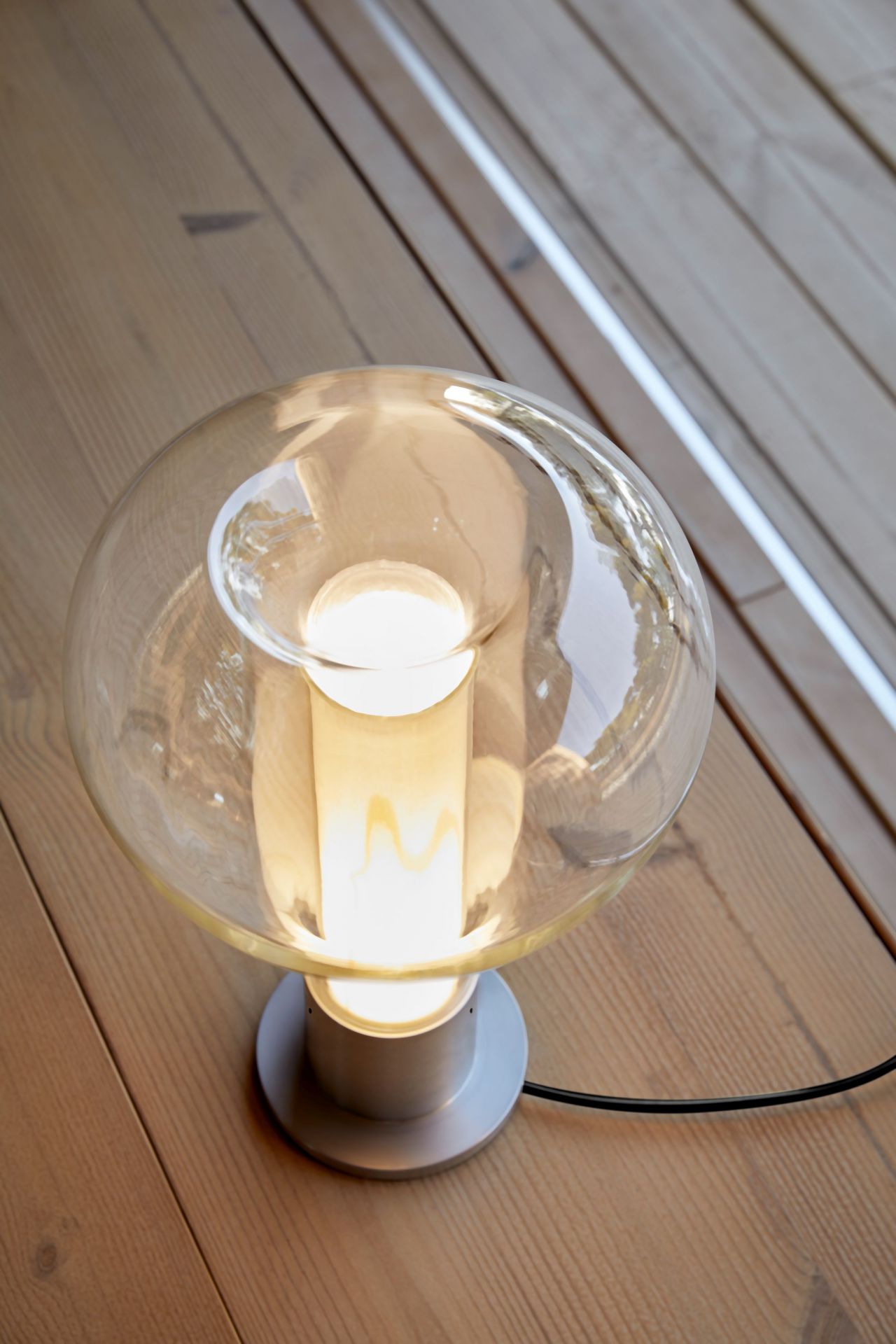 Eris Tischleuchte von LZF Lamps mit Aluminiumsockel und hellrosa Glasschirm, warmes Licht.