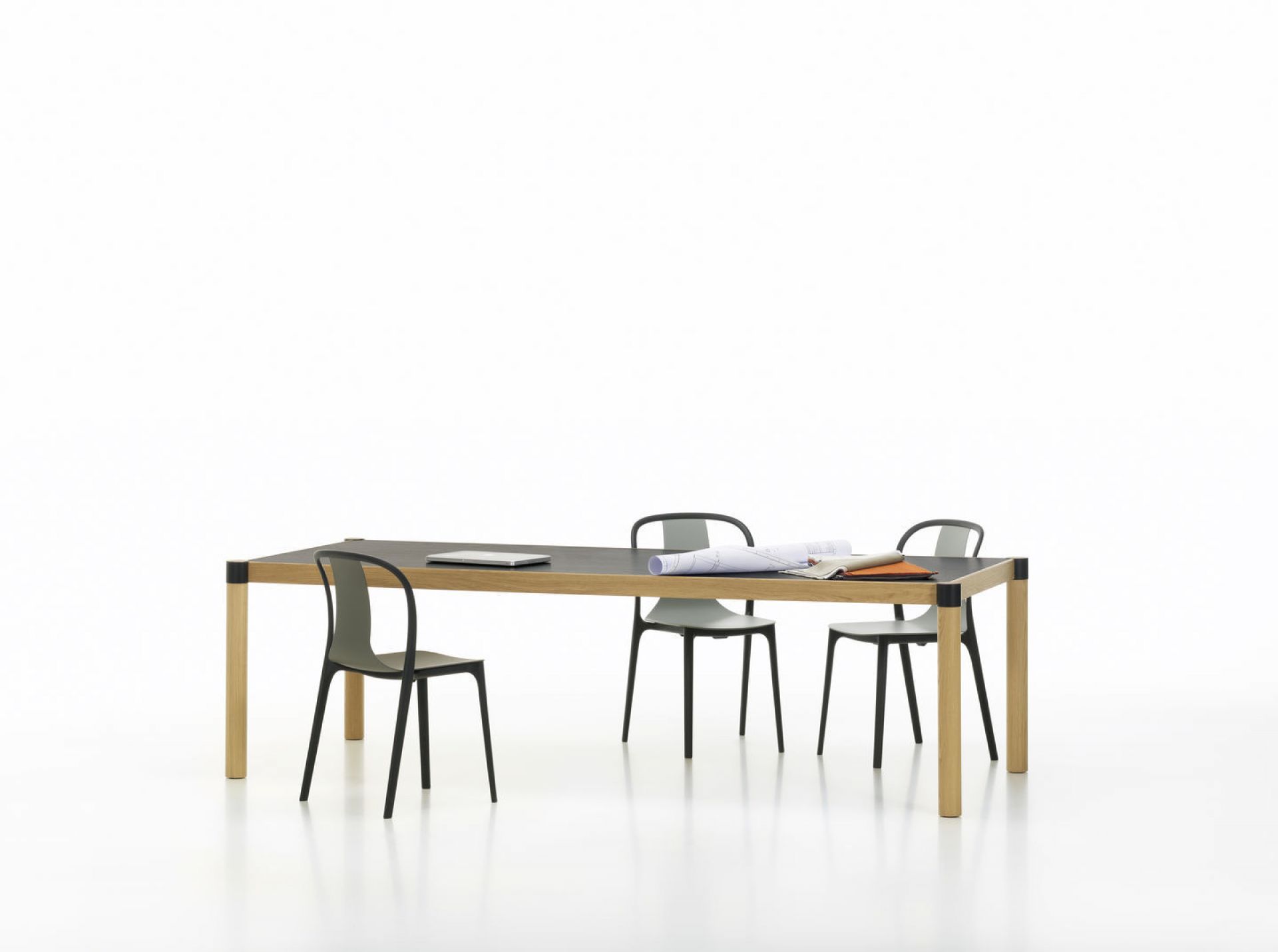 Belleville Armchair Wood Stuhl von Vitra an einem Tisch mit Laptop und Bauplänen.