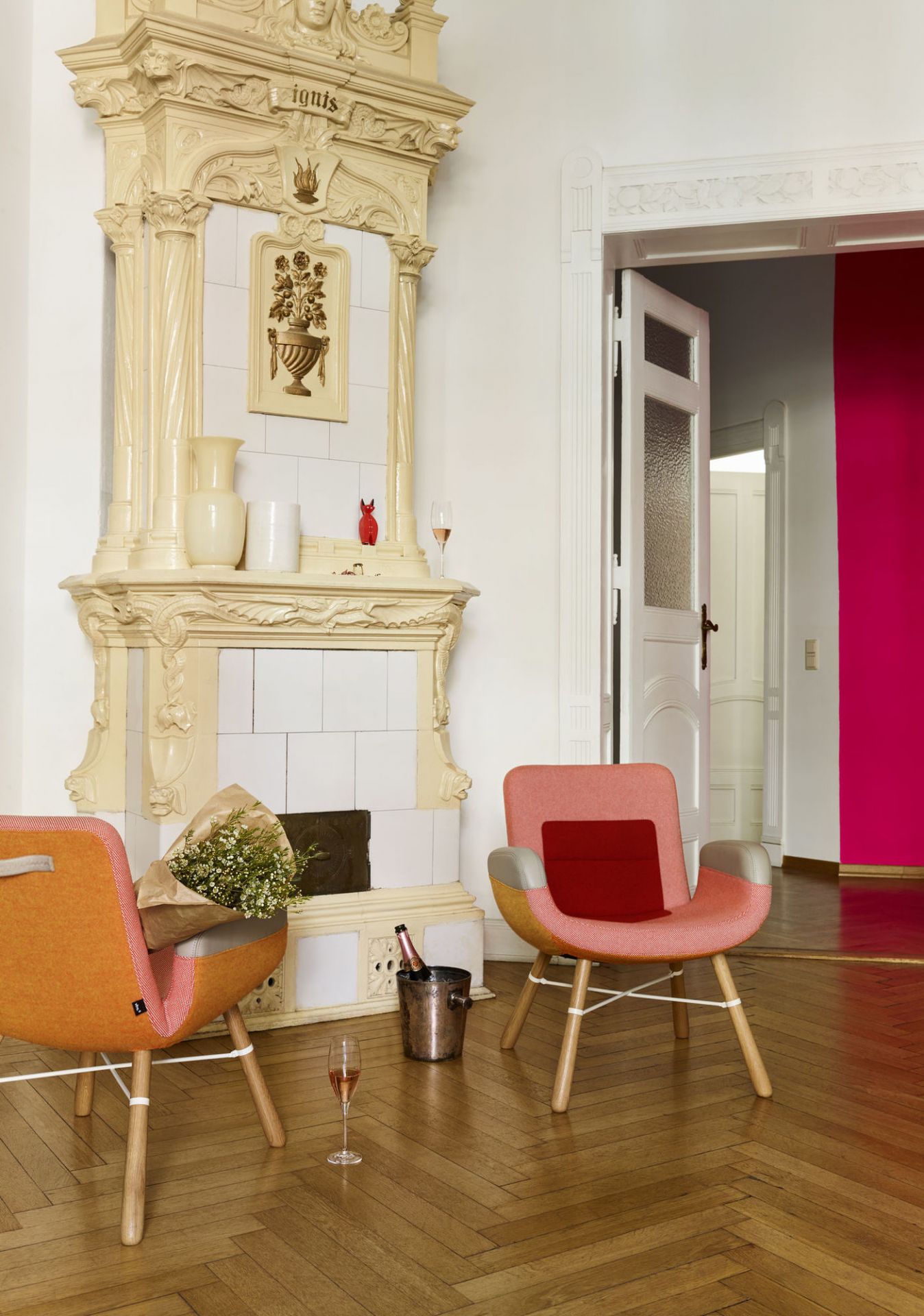 Zwei East River Chair Sessel von Vitra in einem Wohnzimmer mit Kamin und Champagner.