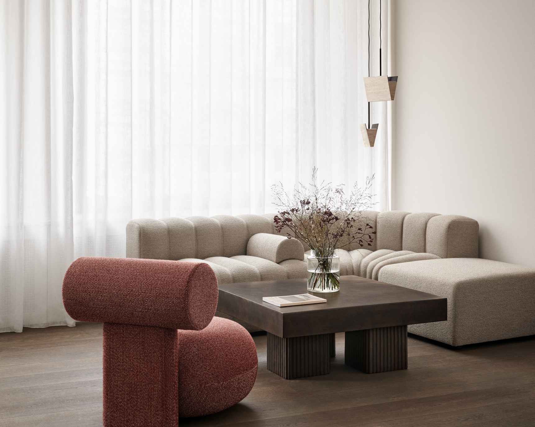 Nahaufnahme des Hippo Lounge Sessels von NORR11, vollgepolstert in Rot, mit Sofa und Couchtisch.