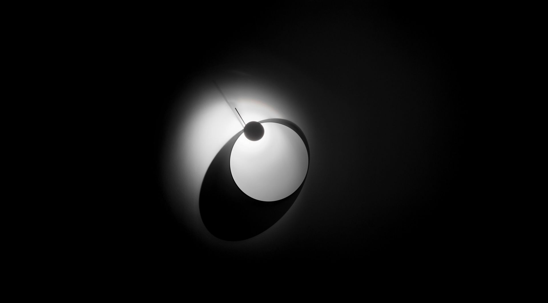 Schwarz-Weiß-Foto der Eclipse Ellipse Wandleuchte von Ingo Maurer. Design Lampe mit besonderem Lichteffekt.