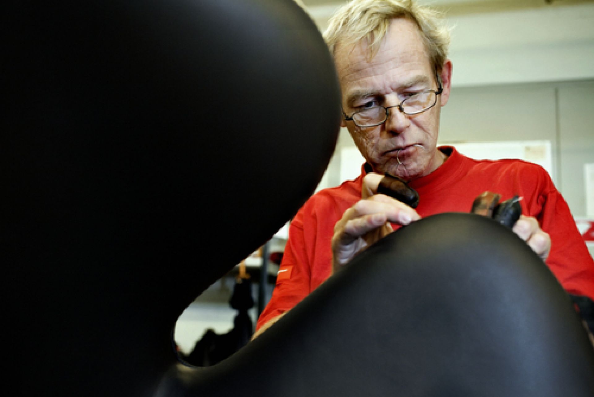 Handwerker fertigt einen schwarzen Schwan Sessel von Fritz Hansen, ein Designklassiker, an.