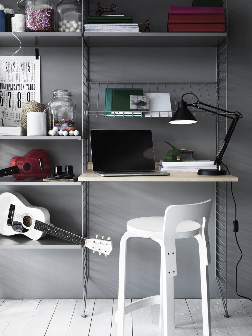 Arbeitsplatz mit String Furniture Regalsystem, Schreibtisch, Laptop, Lampe und Gitarren. Homeoffice Einrichtung.