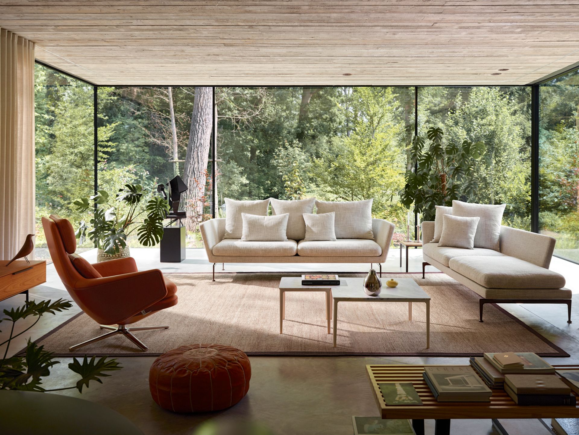Wohnzimmer mit Vitra Grand Relax Sessel in Leder, Sofas und Blick ins Grüne.