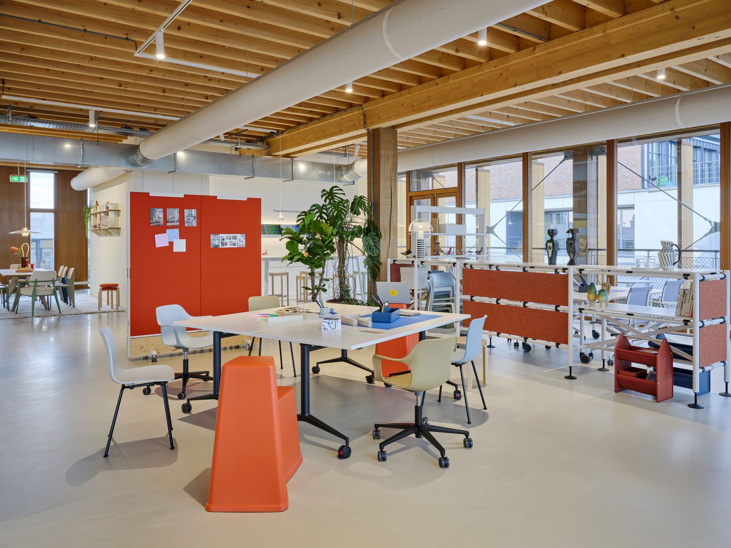 Heller Büroraum mit Vitra MedaMorph Klapptisch, Bürostühlen und modularen Regalen für flexible Arbeitsbereiche.