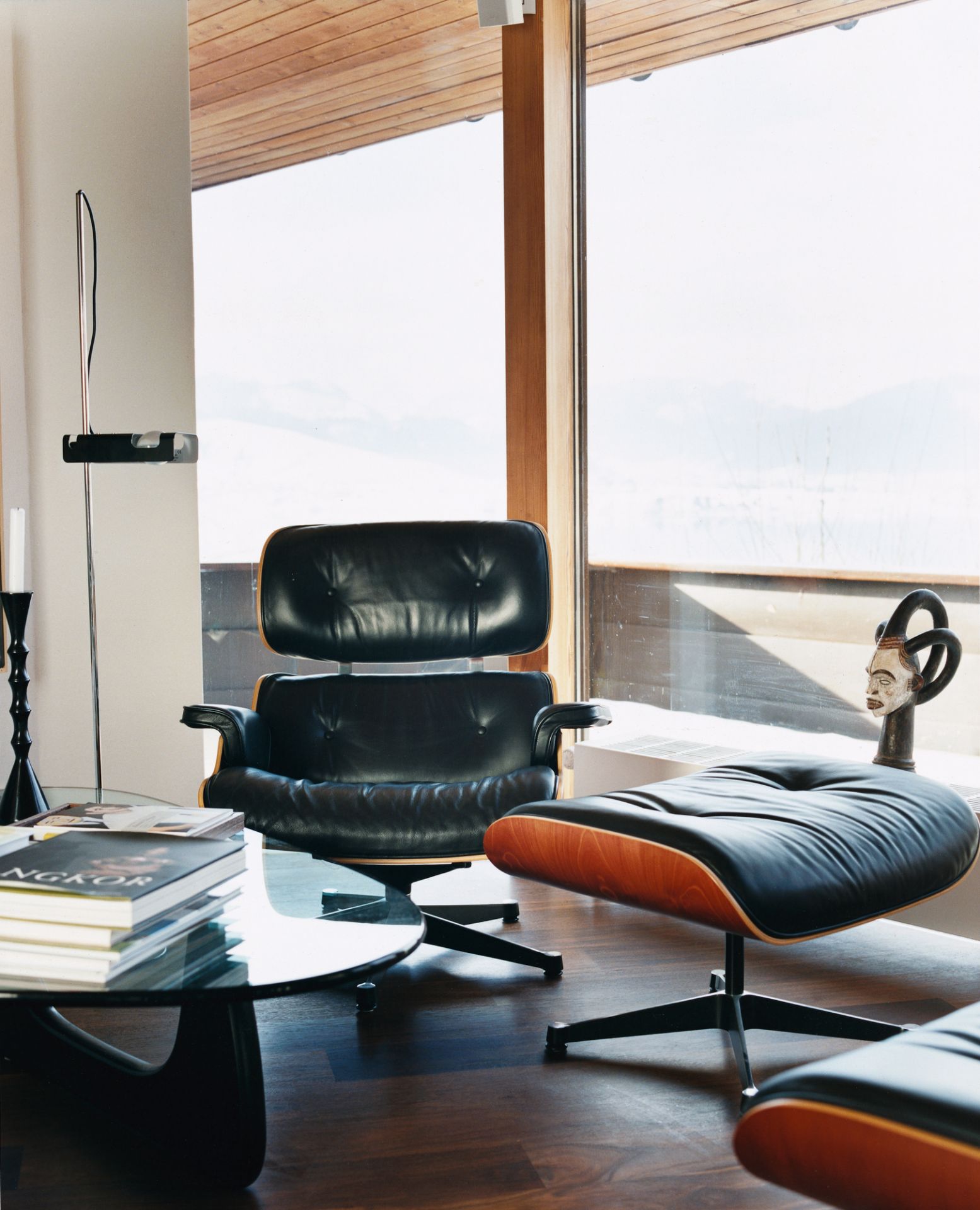 Moderner Wohnraum mit Vitra Lounge Chair, Ottoman und Noguchi Coffee Table mit Glasplatte.