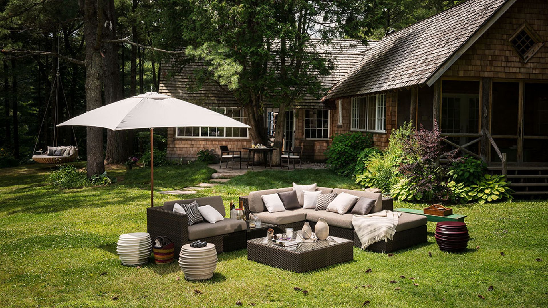Dedon Lounge Modul links im Garten mit Outdoor-Möbeln und Sonnenschirm.