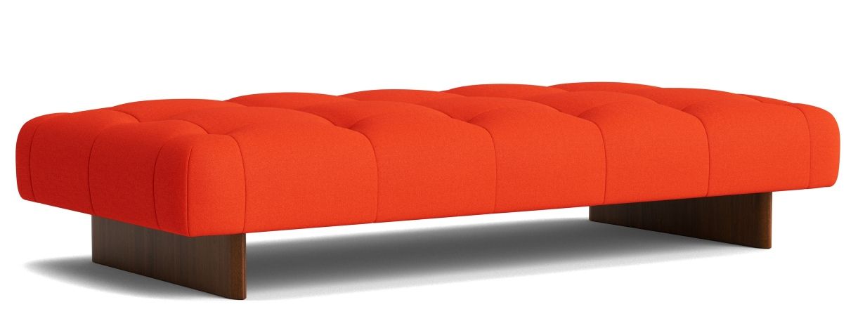Orangefarbene Hay Quilton Daybed Liege mit Knopfheftung und dunklem Holzsockel auf weißem Hintergrund.