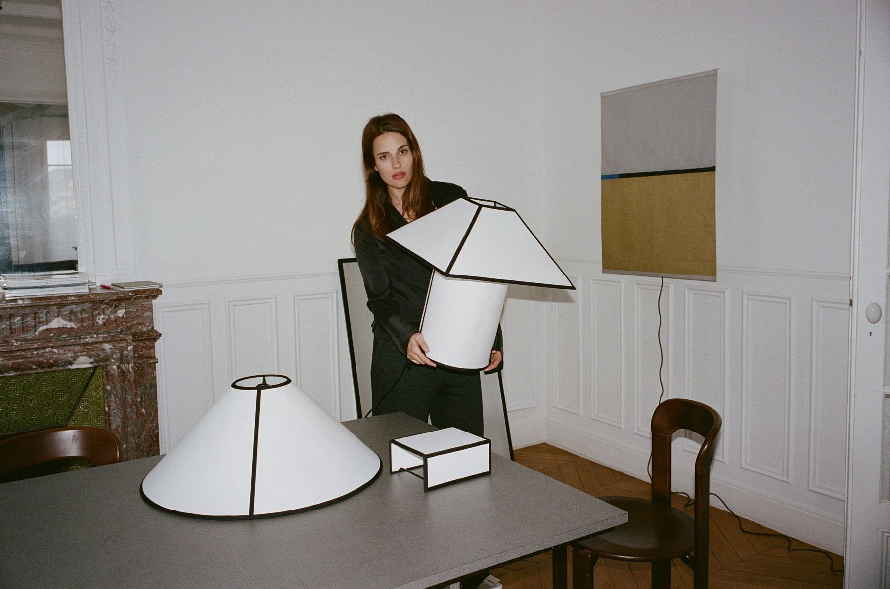 Frau hält Ava Pyramid Table Lamp Tischleuchte von Hay in einem stilvollen Interieur.