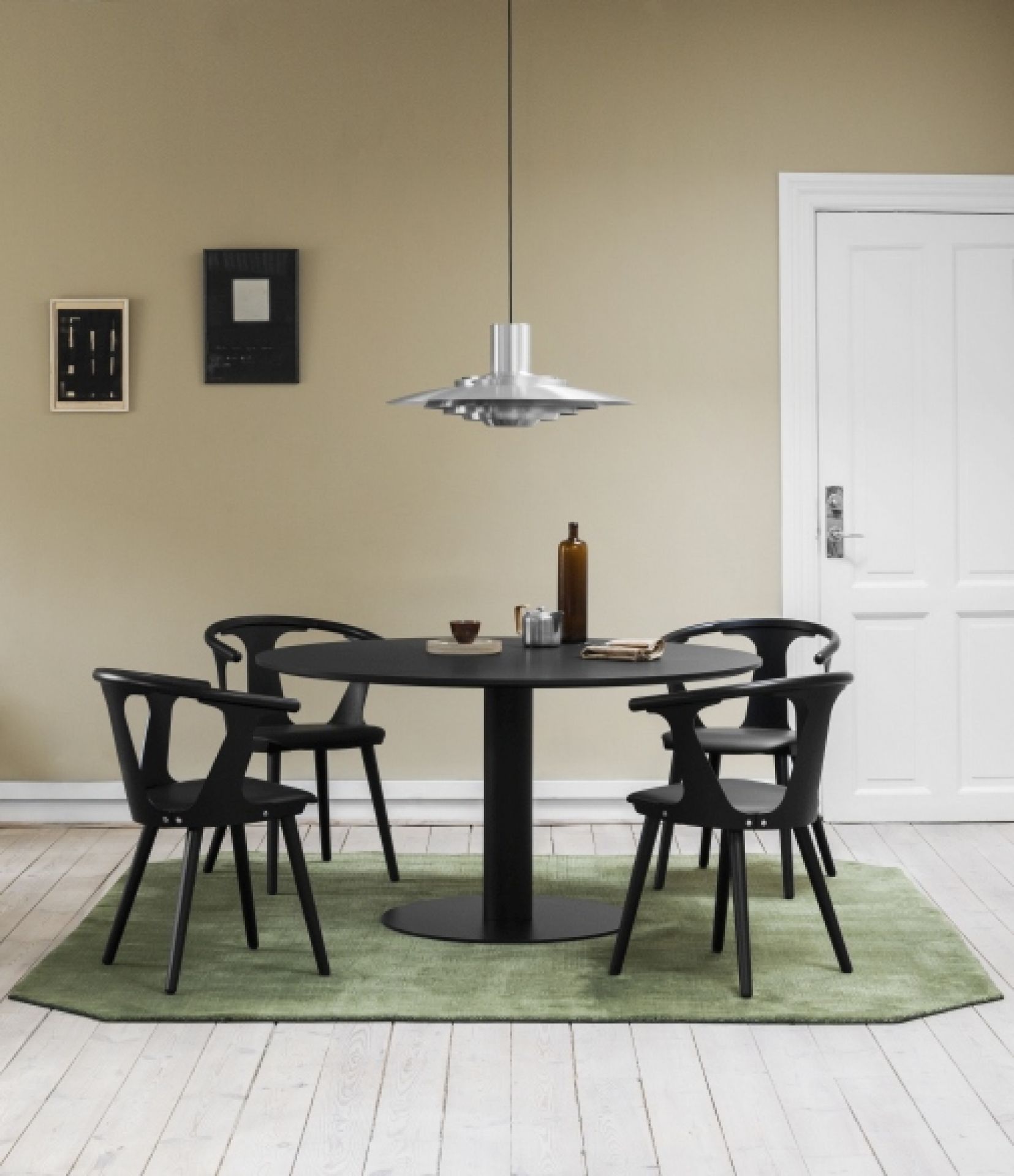 Schwarzer In Between Armchair Armlehnenstuhl SK2 von AndTradition mit Sitzpolster am Esstisch.