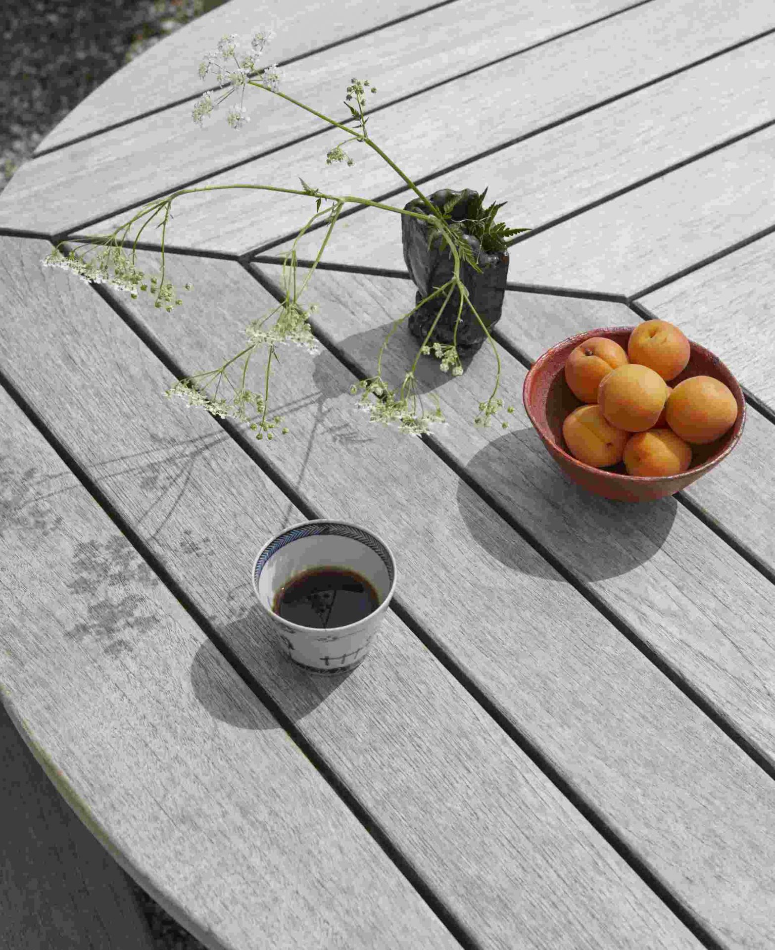 Drachmann Tisch von Skagerak by Fritz Hansen, runder Gartentisch aus Teakholz mit Dekoration.