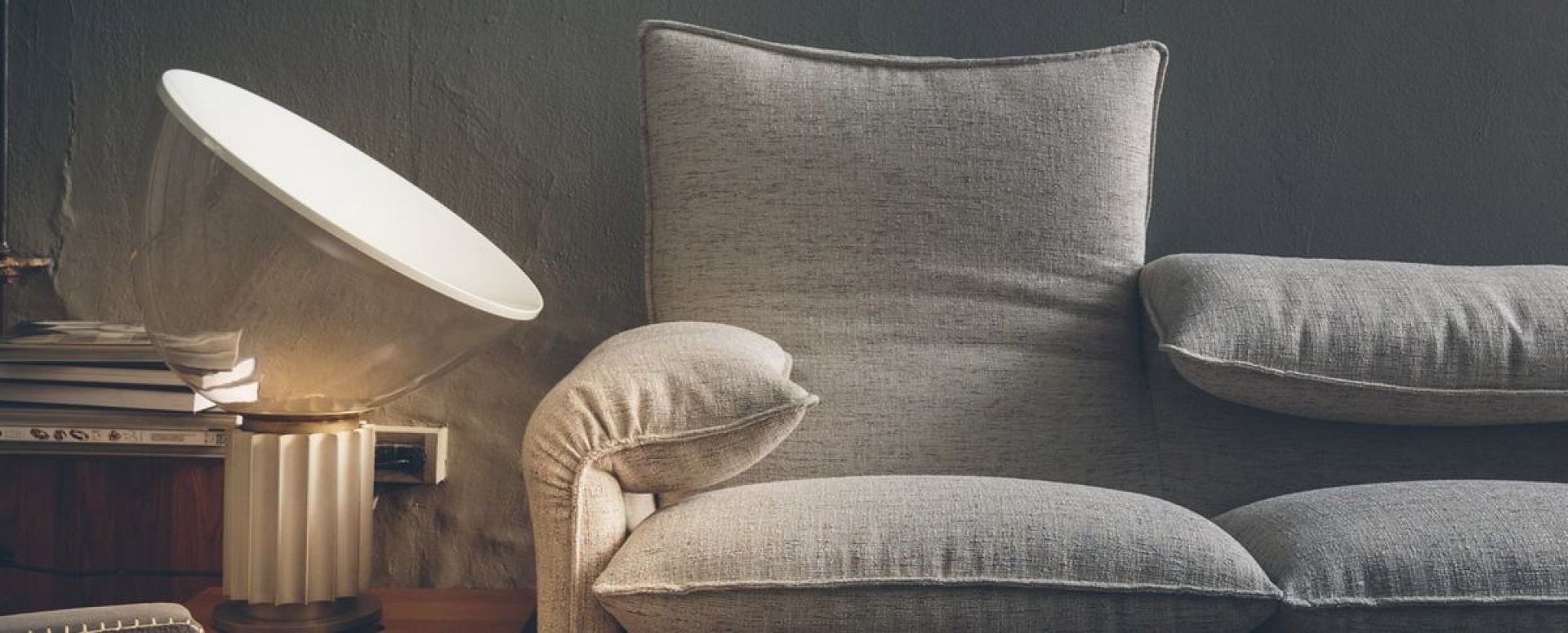 Nahaufnahme des grauen Cassina Maralunga Sofas mit Lampe, luxuriöse Wohnzimmermöbel und modernes Design.