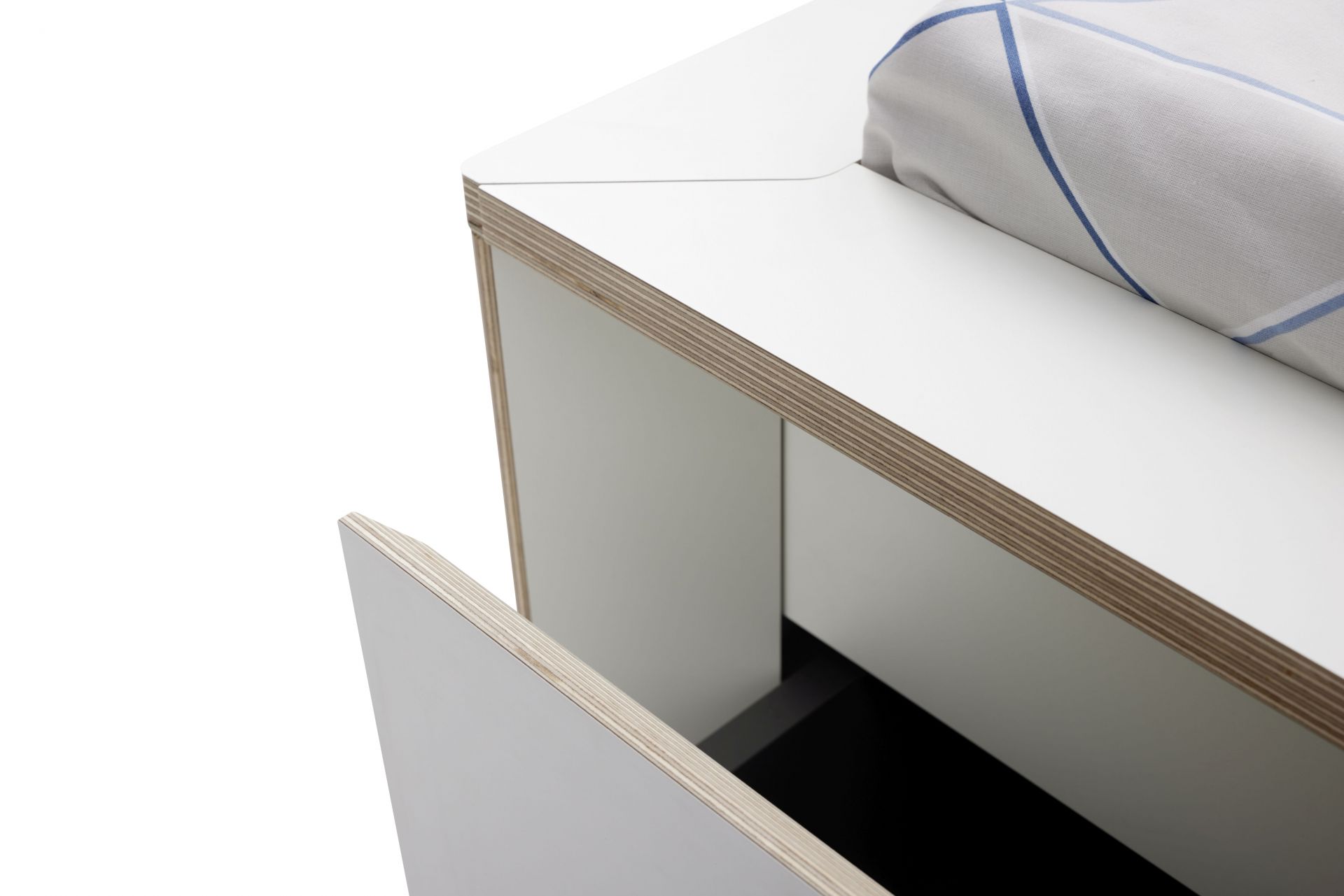 Detailaufnahme vom Spaze Bett von Müller Möbelwerkstätten mit offenem Schubfach und Bettwäsche.