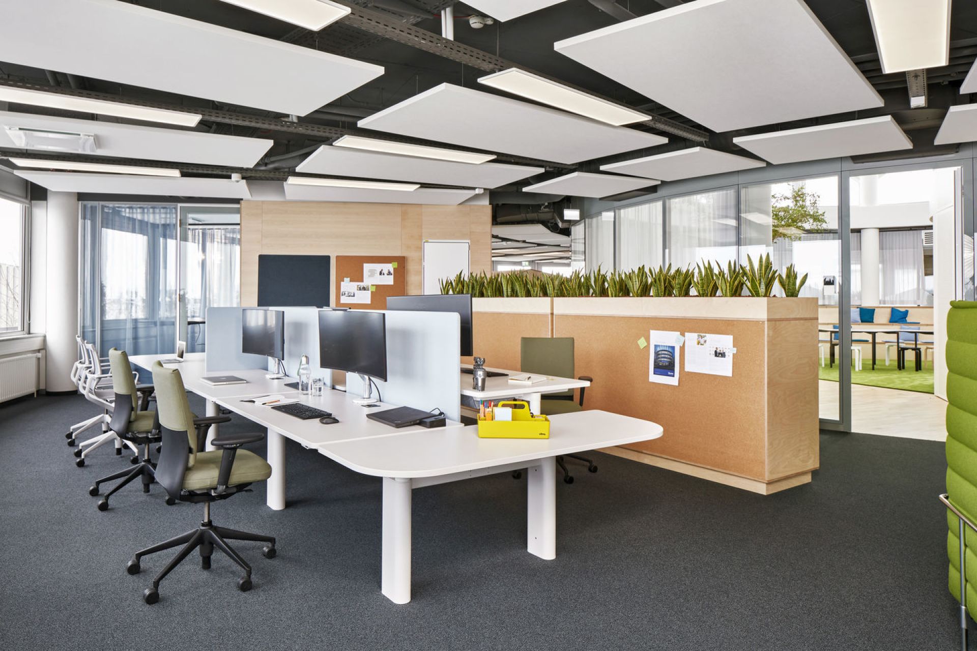 Büro mit Schreibtischen und Vitra ID Soft Bürodrehstühlen in Grün und Weiß für modernes Arbeiten.