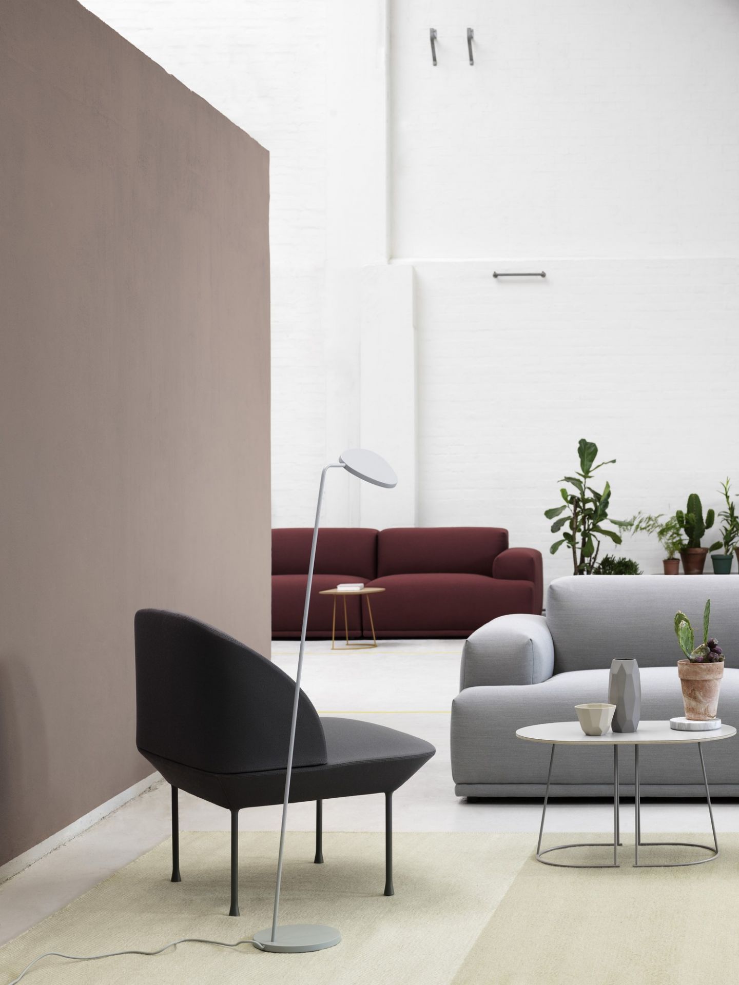 Graues Oslo 1-Sitzer Sofa von Muuto in modernem Wohnzimmer mit Designermöbeln und Pflanzen.