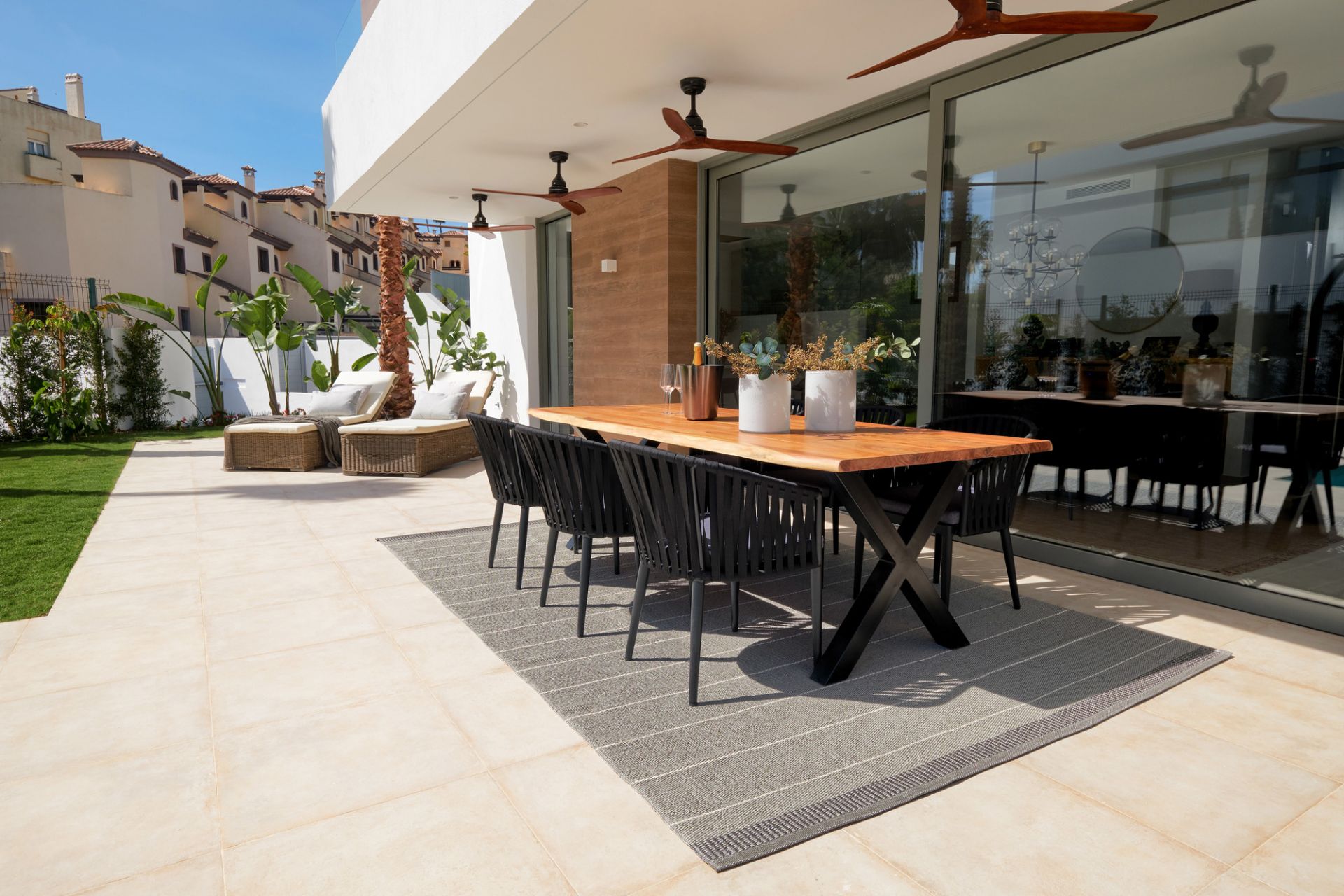 Belle Kunststoffteppich von Pappelina, 60x125 cm, auf einer Terrasse unter einem Esstisch.