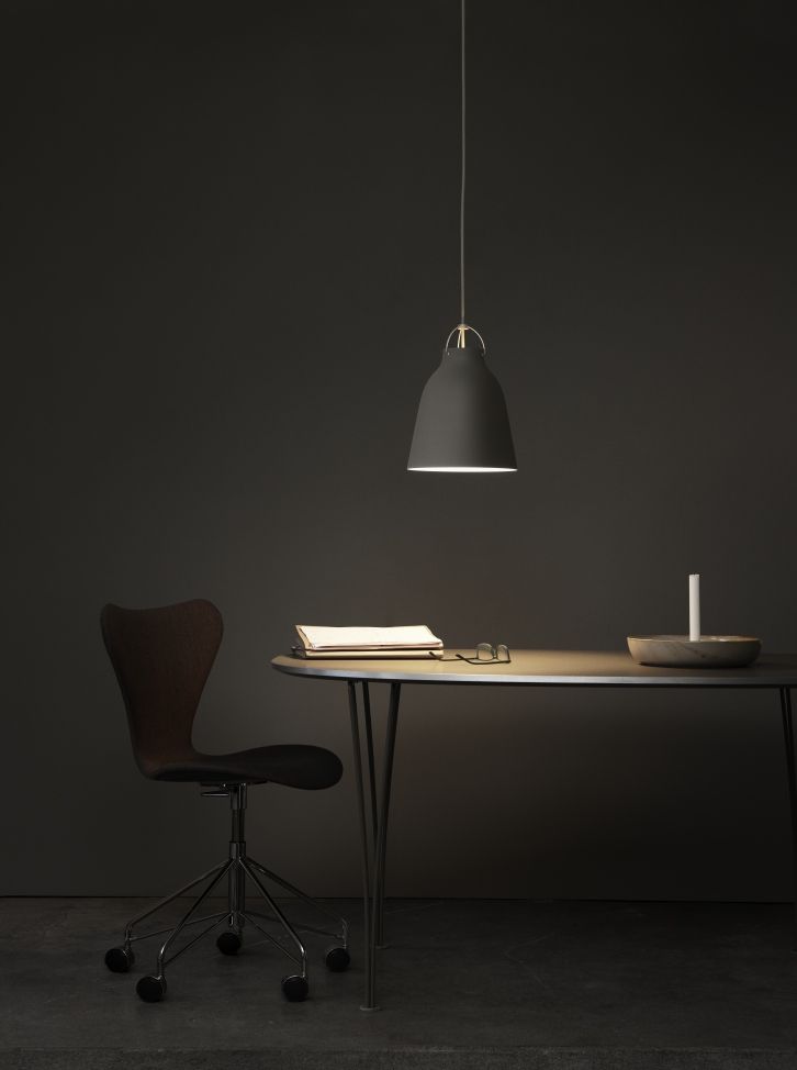 Caravaggio Pendelleuchte von Fritz Hansen, graue Hängelampe über Schreibtisch mit Buch, Brille und Stuhl.