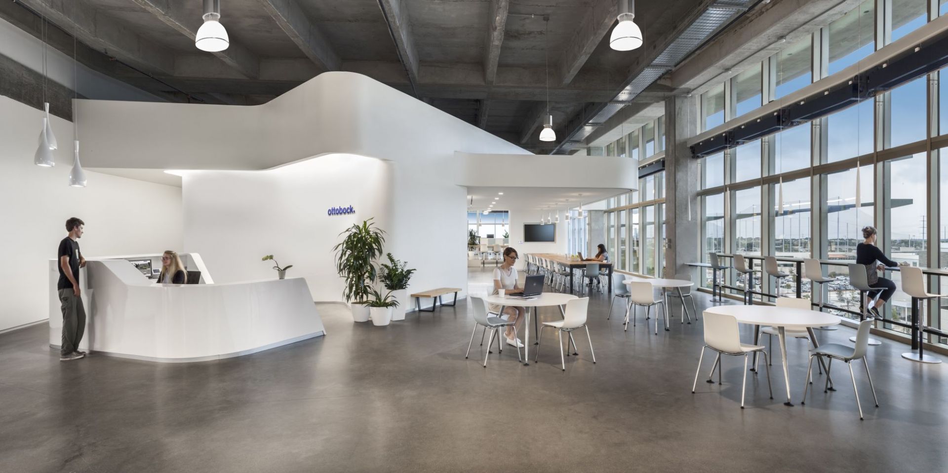Innenaufnahme eines modernen Büros mit Hal RE Barstools von Vitra an einer Fensterbar.