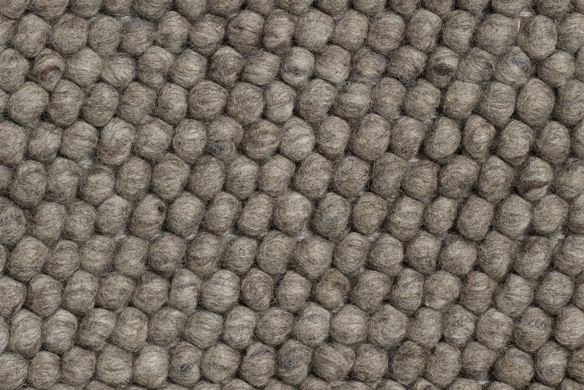 Detailaufnahme des grauen Hay Peas Teppichs mit Wollkugeln, Größe 200 x 140 cm.
